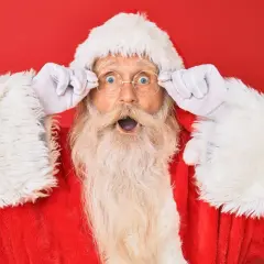Babbo Natale, con gli occhi spalancati e le mani sui suoi occhiali rotondi, sembra sorpreso dalle parole del Natale.
