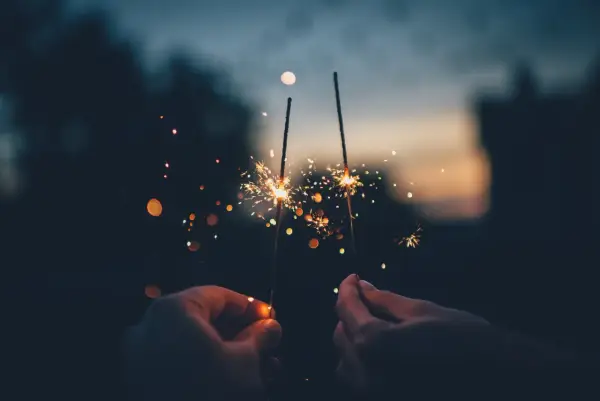Mani che accendono scintille al tramonto, un modo magico per festeggiare, come si dice capodanno in inglese?